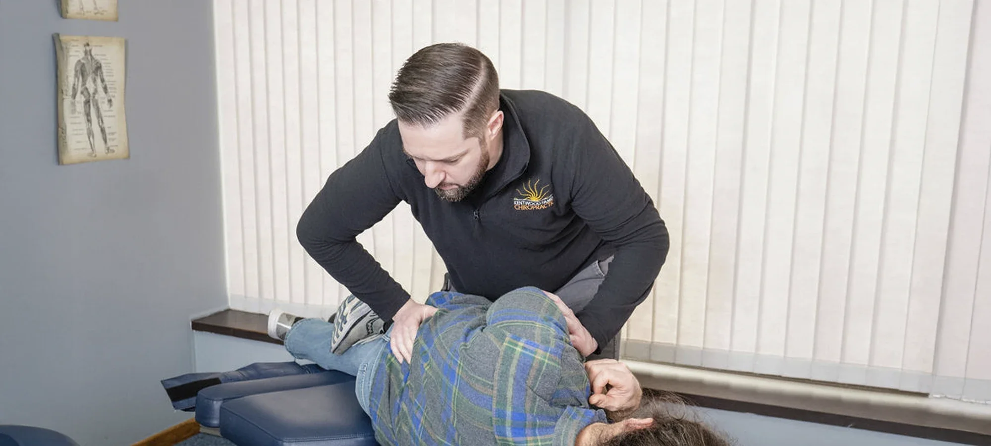Dr. Paul McAllister performing a hands-on low back adjustment at Kentwood Family Chiropractic