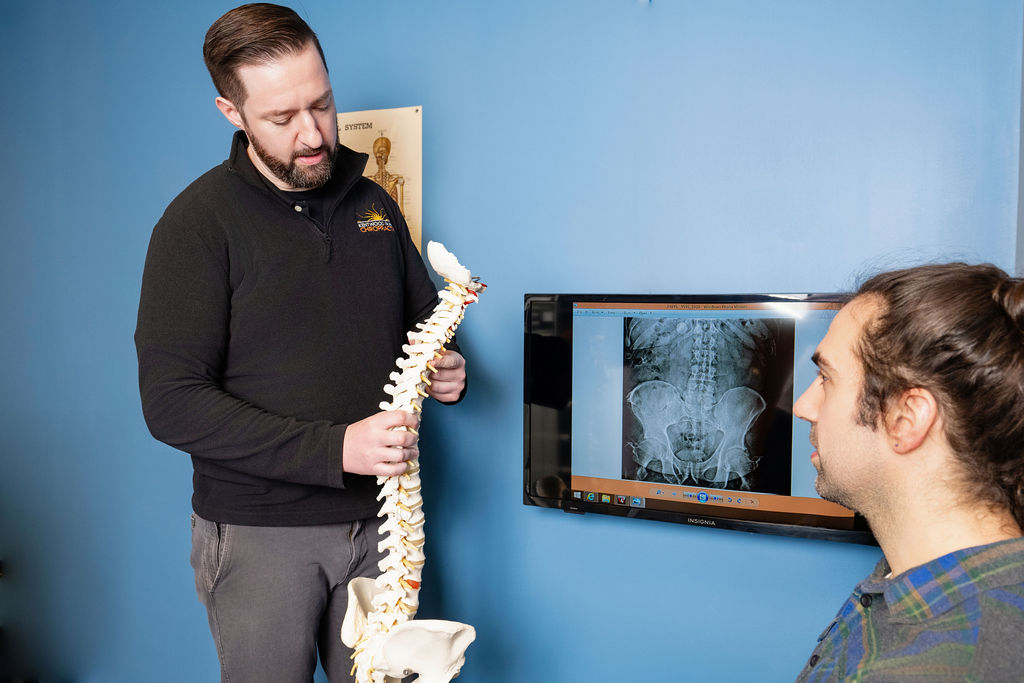 Dr. Paul McAllister explaining spine X-ray findings at Kentwood Family Chiropractic